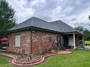 Brick home with new gutter system installed on hip roof