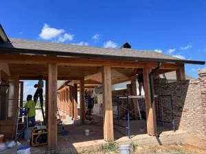 Wood patio structure with installed gutters and exposed beam framing