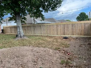 Newly installed wood privacy fence with vertical boards and horizontal rails along residential yard