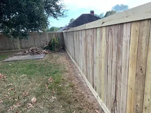Newly installed wood privacy fence with vertical boards along residential property