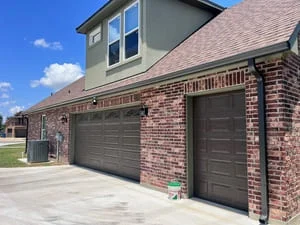 New gutters installed on brick two-story home with garage