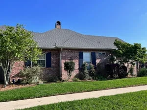 Brick home with new gutter system installed along hipped roof and fascia