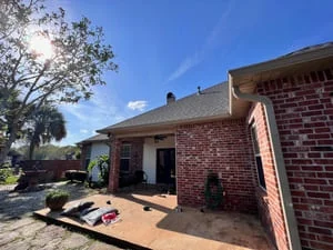 Brick home with newly installed gutters along roofline and fascia