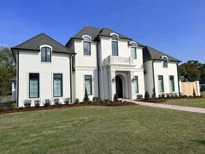 White two-story colonial home with new gutter installation along roofline and fascia