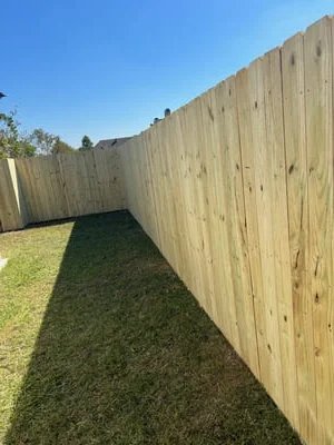 Newly installed wood privacy fence with vertical boards along residential yard