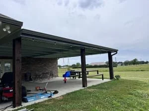 Steel pavilion with installed gutter system on sloped metal roof and support posts