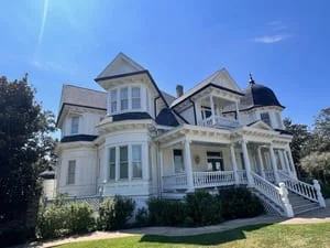 White Victorian home with new gutter system installed along roofline and fascia